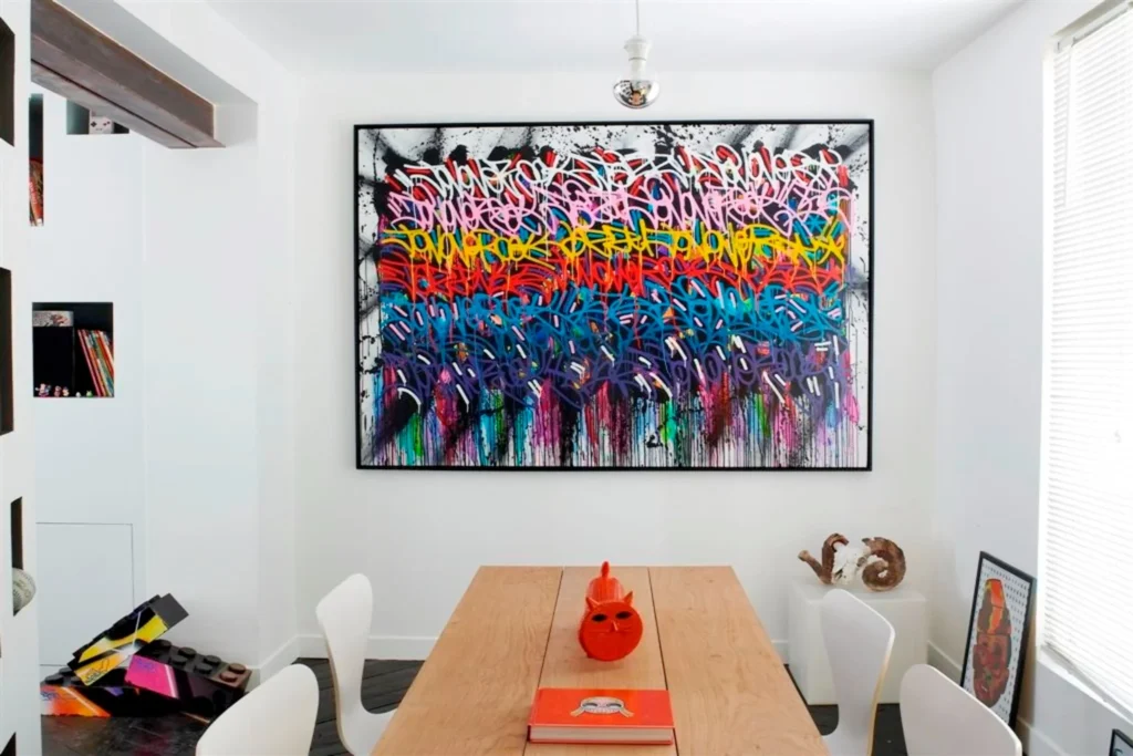 Tableau street art de JonOne mis en valeur dans l’espace repas.
