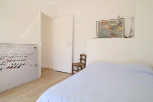 Chambre avec parquet ancien et décoration murale vintage, appartement Paris 17ᵉ – quartier rue Legendre.