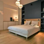 Chambre élégante avec éclairages suspendus design, tête de lit encastrée et rangements intégrés dans un loft à Paris 10.