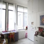 Chambre d’enfant lumineuse avec bureau, rangements intégrés et grandes fenêtres sur cour dans un loft situé à Paris 10ᵉ.