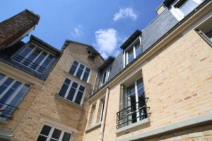 Façade en briques typiquement parisienne d’un immeuble de la rue Legendre, Paris 17ᵉ – ciel bleu et lumière naturelle.