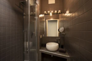 Salle d’eau carrelée avec vasque design et douche vitrée, dans un esprit contemporain et fonctionnel.