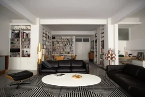 Salon design avec bibliothèques murales dans un loft à Paris rue Martel, mélange de mobilier contemporain et de décoration graphique.