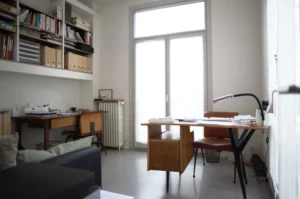 Bureau lumineux avec grands rangements muraux, mobilier vintage et vue sur cour, dans un appartement à vendre Paris 10ᵉ rue Martel.