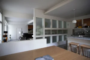 Cuisine ouverte avec verrière moderne dans un loft design rue Martel à Paris.