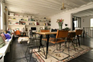 Espace de vie chaleureux avec bibliothèque murale, fleurs fraîches et mobilier vintage