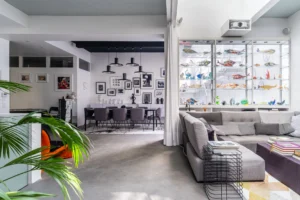Espace salon et salle à manger d’un loft contemporain, avec grande vitrine décorative, lumière naturelle et ambiance design près de Montmartre.