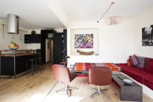 Vue dégagée sur la pièce de vie, cuisine et salon réunis dans un espace ouvert et chaleureux à Paris 15.