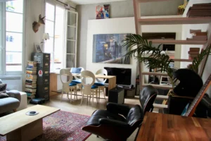 Espace de vie à la décoration soignée, mélangeant mobilier vintage, œuvre picturale et lumière traversante – idéal pied-à-terre à Paris 4ᵉ.
