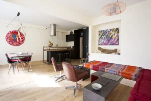 Pièce de vie spacieuse avec salon, salle à manger et cuisine moderne, ambiance lumineuse et artistique.