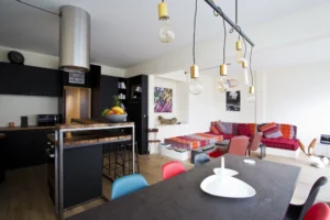 Cuisine ouverte avec îlot central en bois et métal, ambiance industrielle et conviviale à Paris 15.