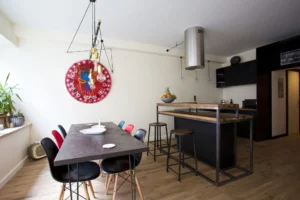 Cuisine design équipée, tons noirs et bois, dans loft à vendre à Paris 15.