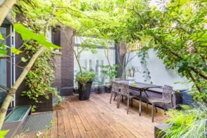 Terrasse aménagée entourée de verdure, avec espace repas extérieur et atmosphère paisible à deux pas de Montmartre.
