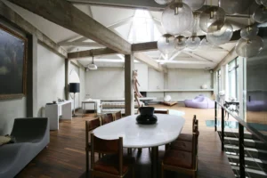 Pièce de réception d’un loft à Bagnolet, avec salle à manger design, mobilier sculptural, éclairage contemporain et volumes généreux sous verrière.