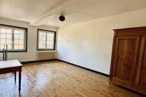 Grande chambre lumineuse avec parquet massif et fenêtres double vitrage, dans un appartement à vendre à Pont-l’Évêque.