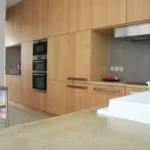 Plan de travail en béton ciré et cuisine bois dans un loft à Paris 10ᵉ