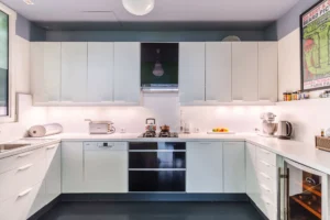Cuisine équipée au design moderne, avec électroménager intégré, nombreux rangements et éclairage doux dans un style fonctionnel.