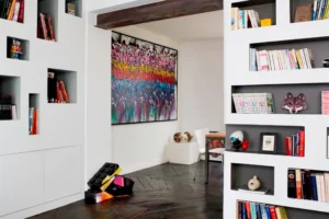 Salon avec bibliothèque et tableau signé JonOne, ambiance loft artistique.
