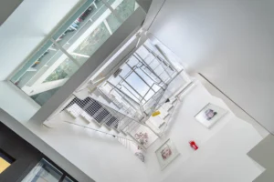 Escalier graphique d’un ancien atelier, transformé en loft et éclairé par une verrière zénithale, décoré d’œuvres murales.
