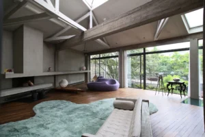 Espace de vie lumineux et ouvert dans un loft à Bagnolet, avec baies vitrées, mobilier design et éléments architecturaux en béton brut.