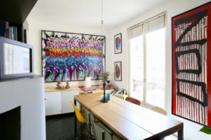 Salle à manger avec grande œuvre de JonOne, mobilier vintage.