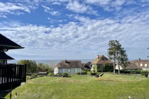 Vue dégagée sur la mer depuis un parc résidentiel à Benerville-sur-Mer, dans un environnement verdoyant typique du Calvados.