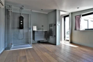 Suite parentale dans un loft à Nanterre avec parquet, douche à l’italienne, vasque suspendue et accès à la terrasse.