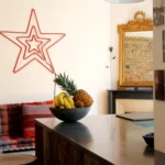 Îlot central avec plan en béton ciré, fruits exotiques et suspensions industrielles dans un appartement design à Paris 19ᵉ.