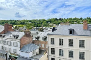 Vue sur les toits d’Honfleur et les collines verdoyantes depuis un appartement à vendre dans le centre historique du Calvados.