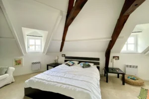 Suite parentale sous combles avec poutres apparentes et double exposition, dans un appartement à vendre à Honfleur.