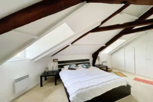 Suite parentale sous combles avec rangements intégrés et poutres apparentes, dans un appartement à vendre à Honfleur.