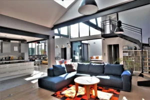Espace de vie lumineux dans un loft à Nanterre, associant cuisine ouverte, salon convivial et verrière atelier en double hauteur.