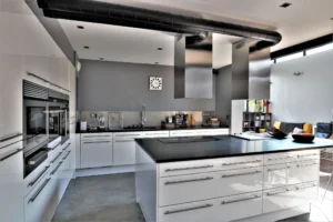 Cuisine contemporaine toute équipée dans un loft à Nanterre, avec électroménager encastré, hotte design et finitions modernes.