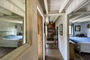 Couloir desservant les chambres avec parquet bois clair et lumière traversante