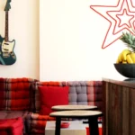 Détail d’un coin salon avec canapé capitonné, tabourets industriels et ambiance pop dans un loft parisien.
