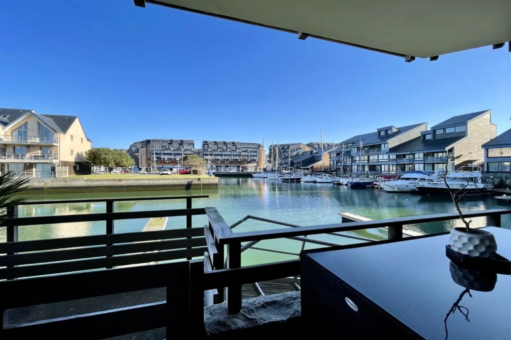 Vue depuis la terrasse de l’appartement en duplex à vendre à Deauville La Marina, donnant directement sur le port et les bateaux.