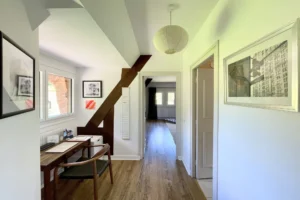 Couloir à l’étage avec coin bureau, parquet bois, lumière naturelle et accès aux chambres à Ouilly-le-Vicomte.
