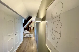 Couloir à l’étage avec rangements intégrés, parquet bois et décoration minimaliste à Ouilly-le-Vicomte.
