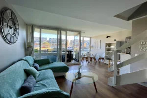 Séjour lumineux de l’appartement en duplex à vendre à Deauville, avec accès à la terrasse et vue sur la marina.