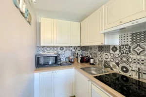Cuisine fonctionnelle de l’appartement en duplex à vendre à Deauville, avec plan de travail et crédence carrelée décorative.