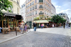 Rue des Abbesses Paris 18 avec commerces, terrasses de café et animation de quartier