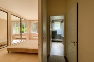 Vue sur une chambre lumineuse avec rangements et accès direct à la salle d’eau, appartement Paris 16 avenue Foch.