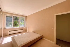 Chambre claire et spacieuse avec grande fenêtre donnant sur verdure, appartement Paris 16 avenue Foch.
