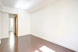 Pièce principale du studio à vendre Paris 18 Abbesses avec parquet et ouverture vers la cuisine