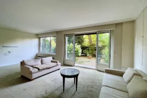Salon lumineux avec baies vitrées donnant sur le jardin particulier, appartement Paris 16 avenue Foch.