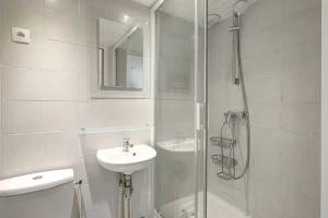 Salle d’eau du studio à vendre Paris 18 Abbesses avec douche vitrée, lavabo et WC