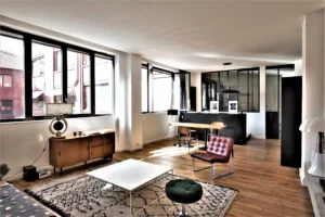 Grand loft lumineux à Paris 11, quartier Parmentier, avec salon design, verrière style atelier et cuisine ouverte contemporaine.
