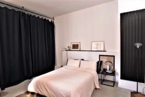 Suite parentale du loft à Paris 11 Parmentier avec décoration minimaliste, grandes tentures noires et touches artistiques.