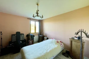 Chambre avec fenêtre sur jardin dans une maison normande à Bonneville-la-Louvet (Calvados).