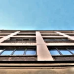 Façade de l’immeuble industriel abritant le loft à Paris 11 Parmentier, style atelier avec grandes fenêtres.